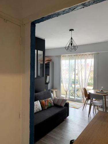 un salon avec un canapé et une salle à manger dans l'établissement Grand Studio avec Balcon au pied de la Plage Clim Wifi, à Saint Cyprien Plage