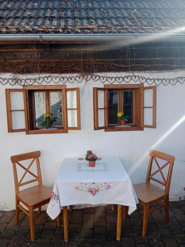 a table with two chairs and two windows at Chaloupka u Mostu sv Jana v centru Vodňan in Vodňany