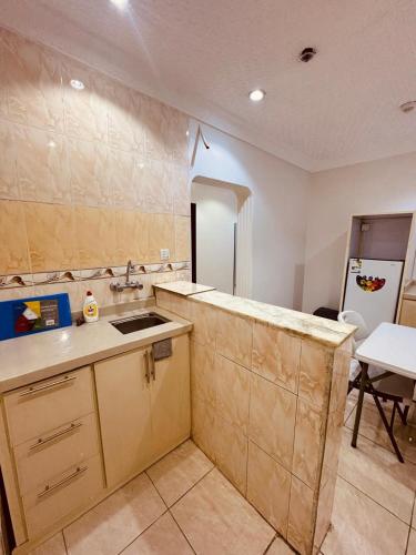 una cocina con fregadero y encimera en عروس الشاطئ للشقق المخدومة, en Umm Lajj