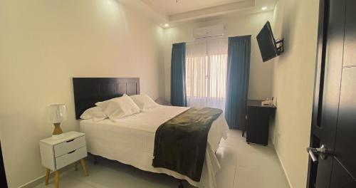 a small bedroom with a bed and a window at Real Guanacaste in San Pedro Sula