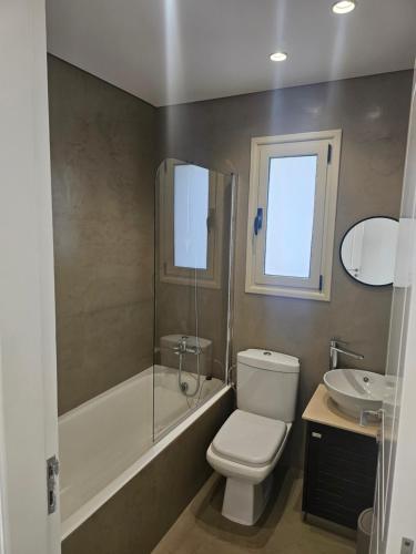 a bathroom with a toilet and a tub and a sink at Villa Enalia Paphos in Paphos City