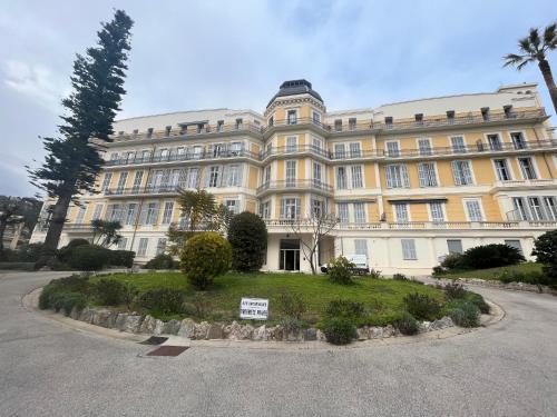 a large white building with a sign in front of it at EXCEPTIONNEL !!! VENEZ SEJOURNER DANS LES 3 SUITES D'UN AUTHENTIQUE ANCIEN PALACE DE LA "BELLE EPOQUE" de 1874 !!! UNIQUE !!! in Menton