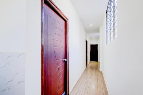 a hallway with a wooden door and a wooden floor at SPOT ON Hari Hara Enterprises in Maula Ali