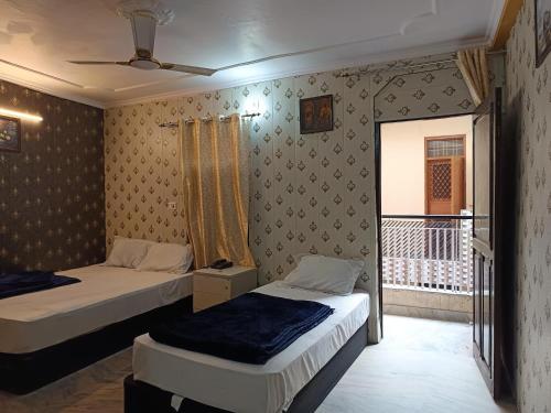 une chambre avec deux lits et un balcon dans l'établissement Haveli Heritage --- 200 Meters from Nizamuddin Railway Station, à New Delhi