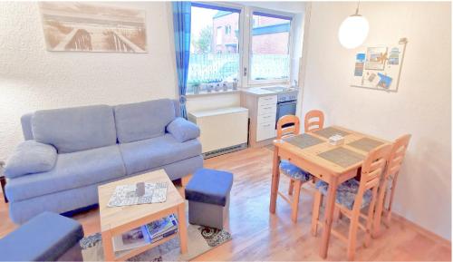Una sala de estar con un sofá azul y una mesa. en Fewo 91 WHG A 8 in Burhave, en Burhave