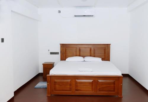 马特勒Linesa holiday resort的卧室里有一张铺着白色床单的木床