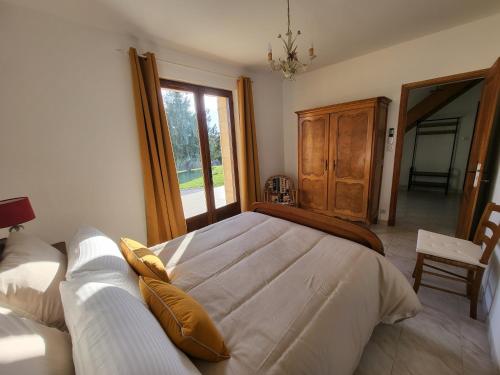 une chambre avec un grand lit et une fenêtre dans l'établissement Gîte du Haut Sarladais, à Sarlat-la-Canéda