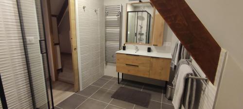 une salle de bain avec un lavabo et un miroir dans l'établissement Gîte du Haut Sarladais, à Sarlat-la-Canéda