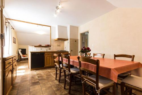 une cuisine avec une table et des chaises dans une pièce dans l'établissement Les Gites du Finet -Châtel, à Lalley