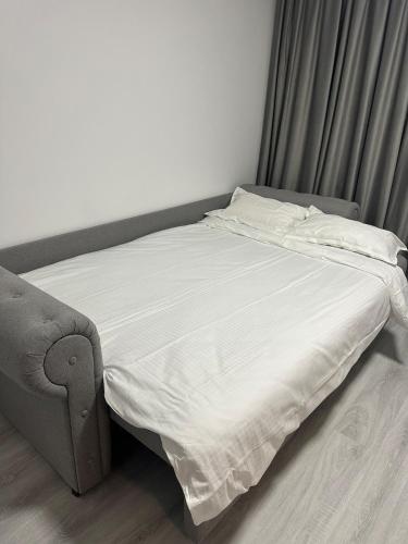 - un lit dans une chambre à côté d'un canapé dans l'établissement Affordable Cute & Comfy Flat, à Dobroeşti