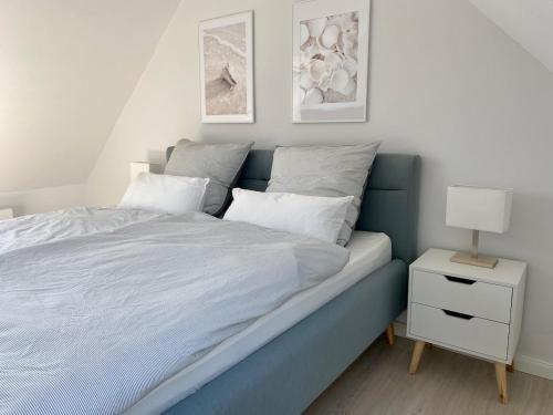 a bedroom with a blue bed and a night stand at Ferienwohnung Herzmuschel in Varel