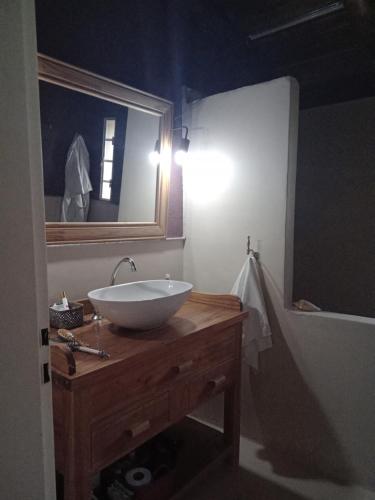 a bathroom with a white sink and a mirror at Casa Chakana in La Cumbre