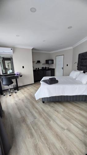 a bedroom with a bed and a desk and a computer at Lavender Lofts in Centurion
