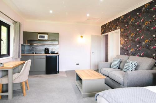 a living room with a couch and a kitchen at Cricklade House Hotel, Sure Hotel Collection by Best Western in Cricklade