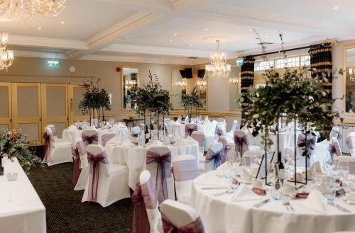 a room filled with tables with white tablecloths at Cricklade House Hotel, Sure Hotel Collection by Best Western in Cricklade