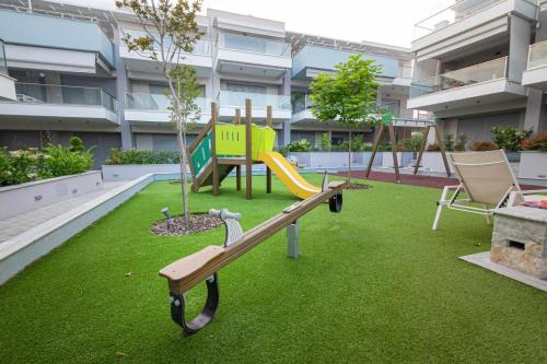 a playground with a slide and a tree in a building at Elymara Family Vacation Home in Nikiti