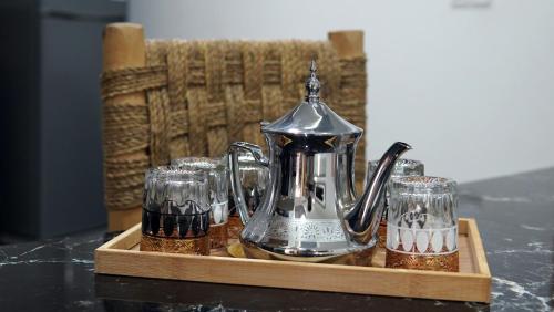 a tea kettle and glasses on a wooden tray at Appartement lux dakhla in Dakhla
