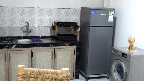 a kitchen with a refrigerator and a washing machine at Appartement lux dakhla in Dakhla