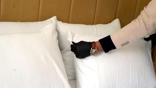 a man with a watch on a bed with pillows at Appartement lux dakhla in Dakhla