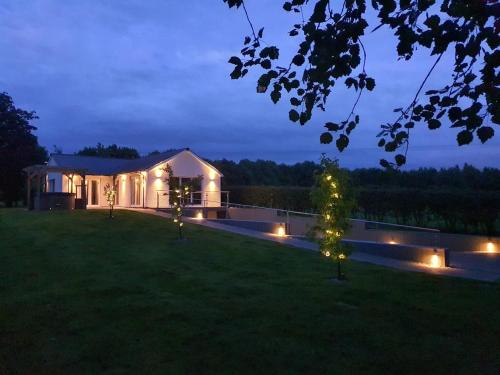 a house with lights in the yard at night at Orchard Cottage At Gretna in Gretna