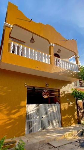 a yellow building with a balcony and a garage at Residence Brisa in Jericoacoara