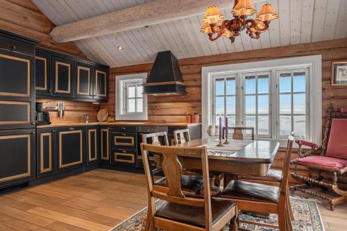 a kitchen with a table and a dining room at Tømmerhytte i Valdres med panoramautsikt over fjellene in Aurdal