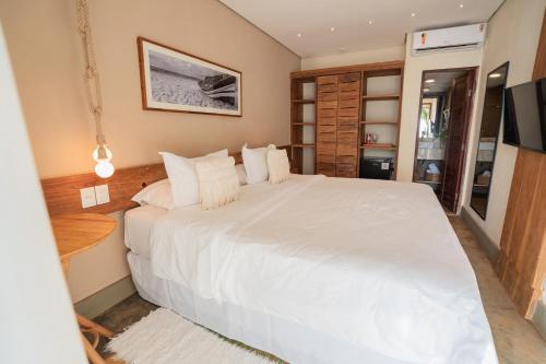 a bedroom with a large white bed in a room at Hotel da Pipa in Pipa