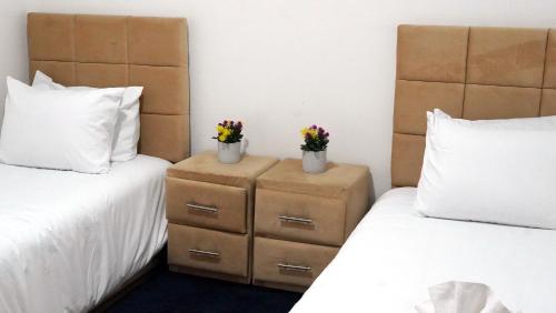 two beds in a room with flowers in vases at Hébergement lux dakhla in Dakhla