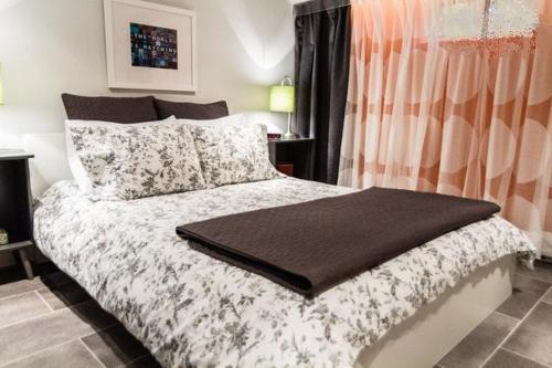 a bedroom with a bed with a blanket on it at L'Adresse Botanique - Studio in Montréal