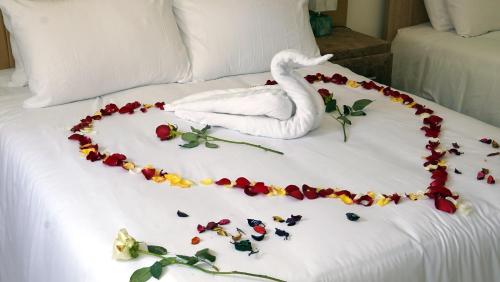 a white swan decoration on a bed with flowers at Hébergement lux dakhla in Dakhla
