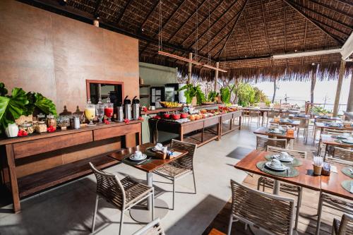 a restaurant with tables and chairs and a buffet at Hotel da Pipa in Pipa