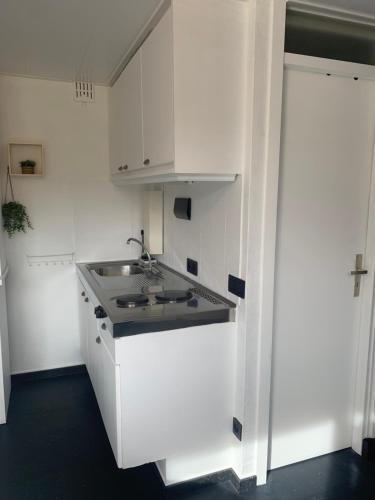 a kitchen with white cabinets and a sink at Studio Cosy au coeur de Han-sur-Lesse in Han-sur-Lesse