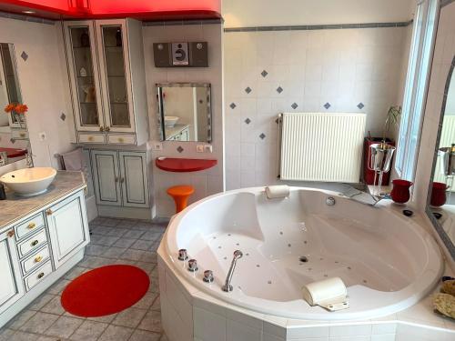 La salle de bains est pourvue d'une grande baignoire et d'un lavabo. dans l'établissement Issy Zen House Spa - Paris Expo - Porte de Versailles - Maison 140m2 - Proche Roland Garros, à Issy-les-Moulineaux