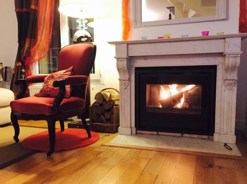 - un salon avec une cheminée et une chaise dans l'établissement Issy Zen House Spa - Paris Expo - Porte de Versailles - Maison 140m2 - Proche Roland Garros, à Issy-les-Moulineaux