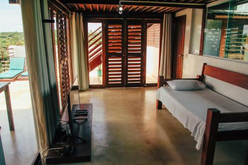 a bedroom with a bed and a view of a balcony at Pipa Panorama Aparthotel in Pipa