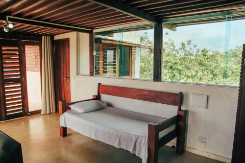 a bed in a room with a large window at Pipa Panorama Aparthotel in Pipa