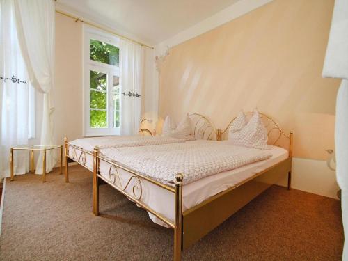 a bedroom with a bed with white sheets and a window at Wohnung in Zahrensdorf bei drei Seen in Zahrensdorf