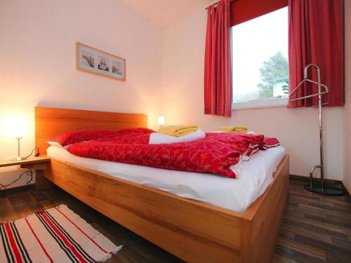una camera da letto con un letto con lenzuola rosse e una finestra di Ferienwohnungen am Plauer See, Zislow a Zislow