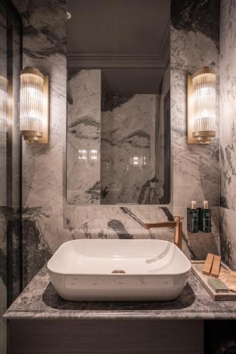 a bathroom with a white tub on a marble counter at Gagos Suites - Center in Larisa