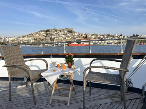 a table and chairs on the deck of a boat at Exclusive Yacht Stay - Best Sea & Old Town Views - Prime Location in Kavala