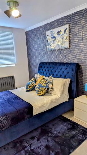 a bedroom with a blue bed with pillows on it at Crystal Palace Stylish gfloor 1bed apartment,3 minutes walk to Crystal palace station in London
