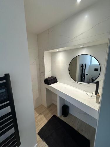 une salle de bain blanche avec un miroir et un lavabo dans l'établissement Studio, à Le Poiré-sur-Vie