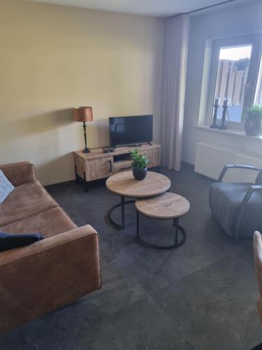 a living room with a couch and two tables at Hemmer Hofstede in Hem