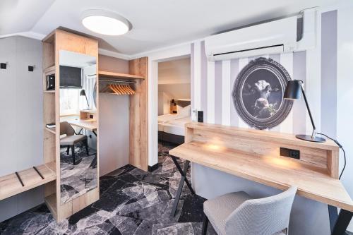 a room with a desk and a bed at Das Landhotel am Trätzhof Fulda in Fulda