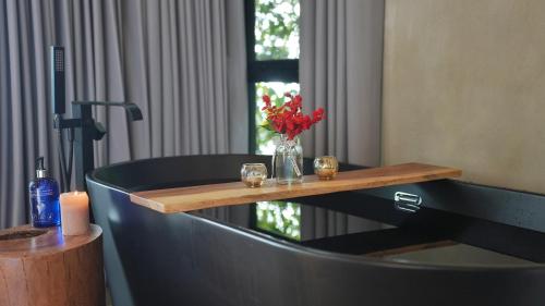 a bath tub with a vase of flowers and candles at Amalú Luxury View Cabins in Monteverde Costa Rica