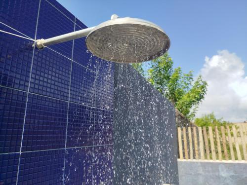 a water fountain in front of a blue building at Casa Areia Bela - Patacho in Pôrto de Pedras