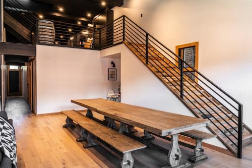 a room with a wooden table and a staircase at Downtown Loft with Rooftop Hot Tub by StayIn in Fernie