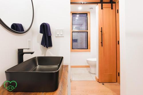 a bathroom with a black sink and a mirror at Downtown Loft with Rooftop Hot Tub by StayIn in Fernie
