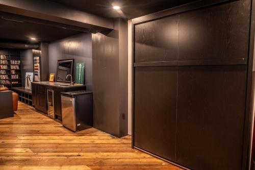 a kitchen with a refrigerator and a counter in a room at Downtown Loft with Rooftop Hot Tub by StayIn in Fernie