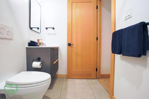 a bathroom with a toilet and a blue towel at Downtown Loft with Rooftop Hot Tub by StayIn in Fernie